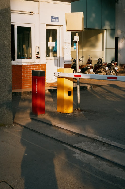 Barrier gate with red and yellow bollards at entrance